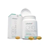 A white bottle of Cibdol 5% CBD softgels capsules (60 pieces – 8.3 mg) with a labeled box beside it. Three softgel capsules are placed in front of the packaging.